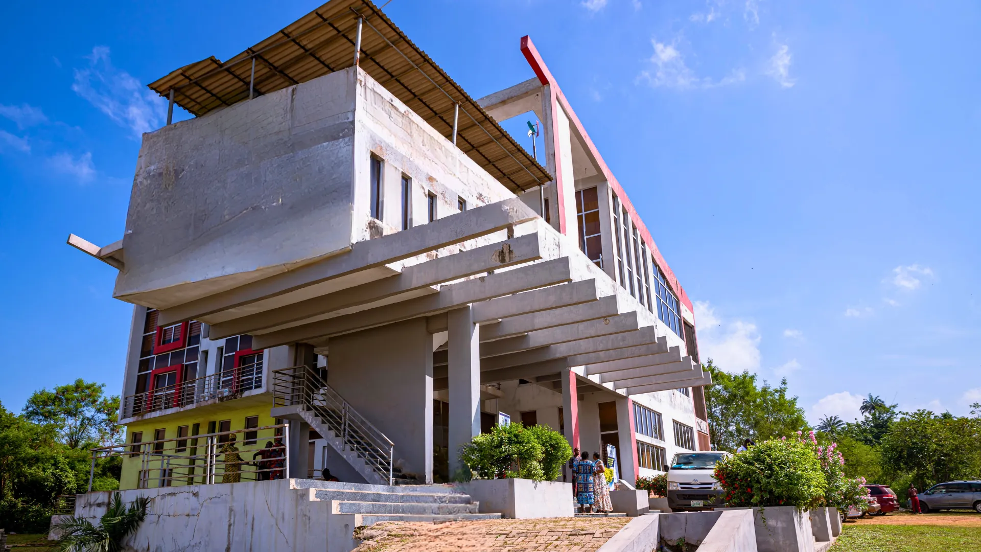 Exterior of a multi-storey building with projecting roof panels under a blue sky.